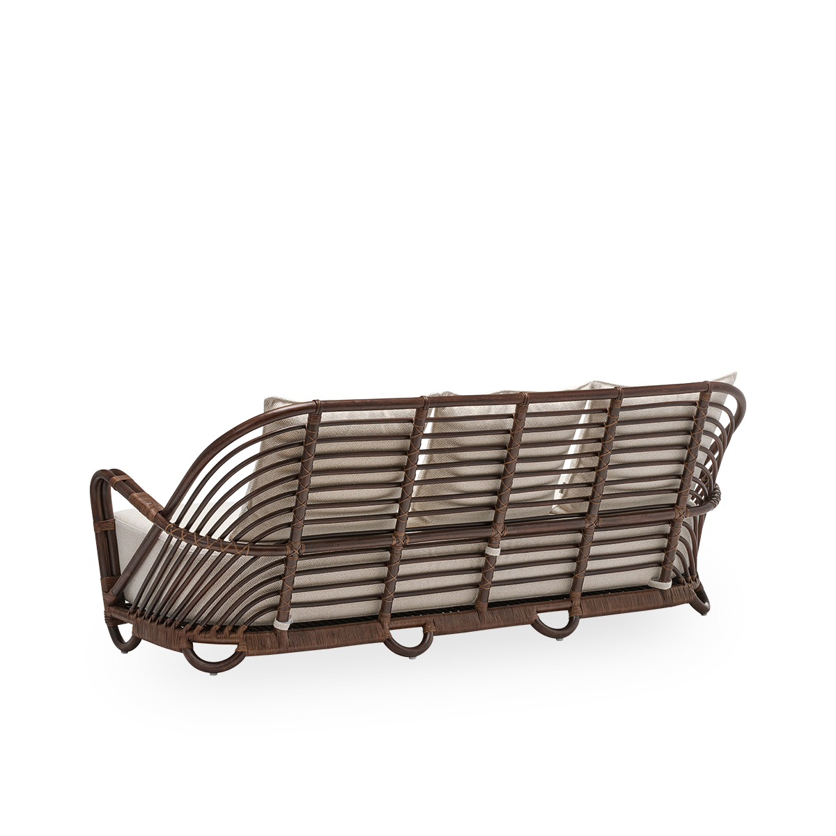 Skrå bagvisning af Charlottenborg 3-personers sofa med sæde- og ryghynder, i brun rattan. Oprindeligt designet af Arne Jacobsen i 1936; det buede ryglæn glider elegant over i armlænene. Håndlavet i rattan.