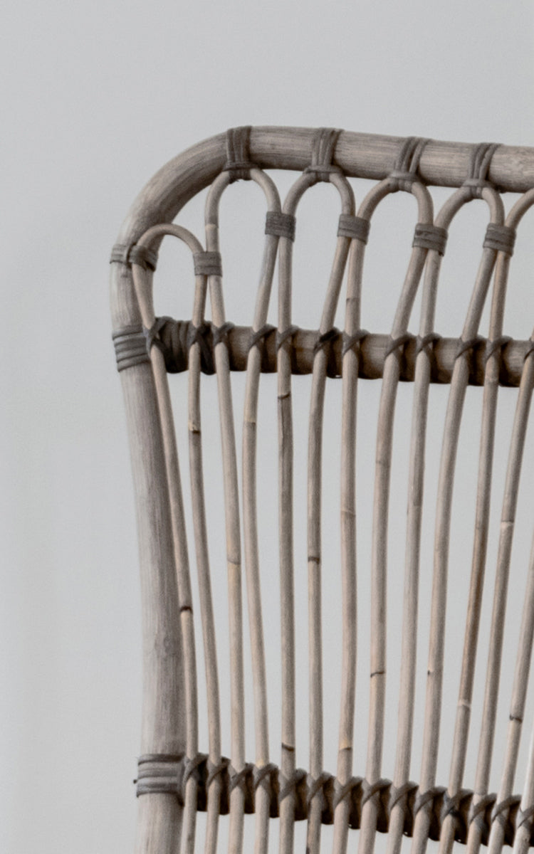 Dette er et nærbillede af Monet Lounge Chair i taupe rattan. Detalje af sløjfebue-designet og vertikale stænger i varm taupe-tone.