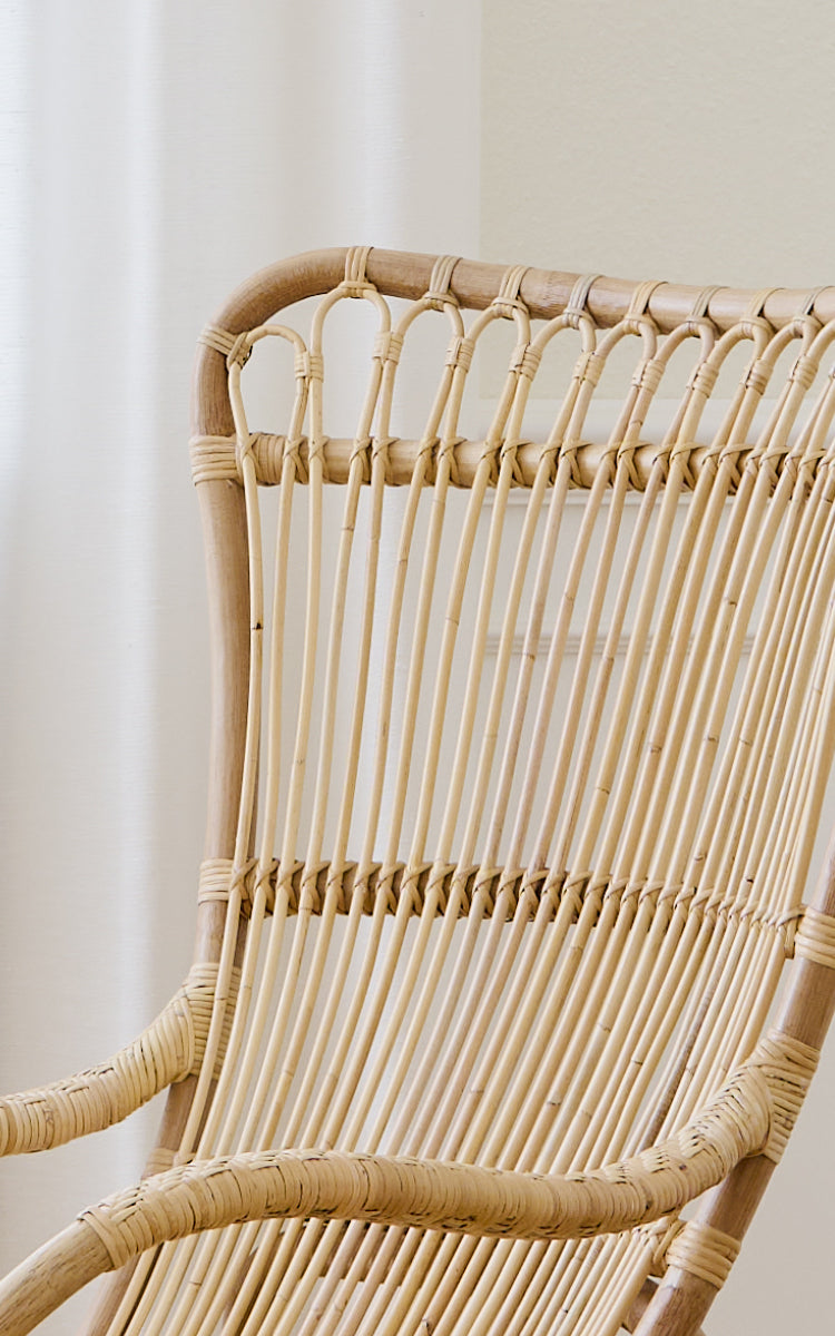 Dette er et nærbillede af Monet Lounge Chair i natural rattan. Detalje af sløjfebuerne og de glatte vertikale rattanstænger.