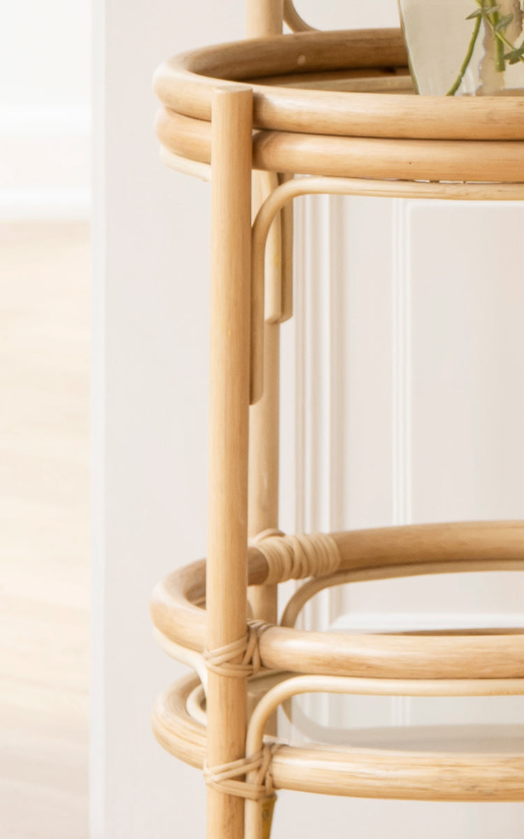 Dette er et nærbillede af Romeo Trolley i natural rattan. Detalje af det toetages rattanstel med glashylde og messinghjul.
