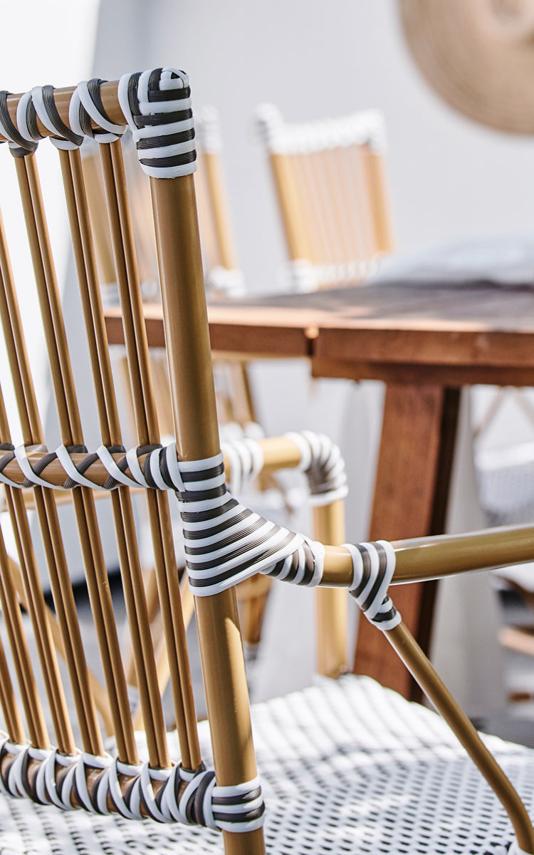 Dette er et nærbillede af Monique Exterior Dining Armchair i white w cappuccino dot ArtFibre. Detalje af prikfletten og armlænet.