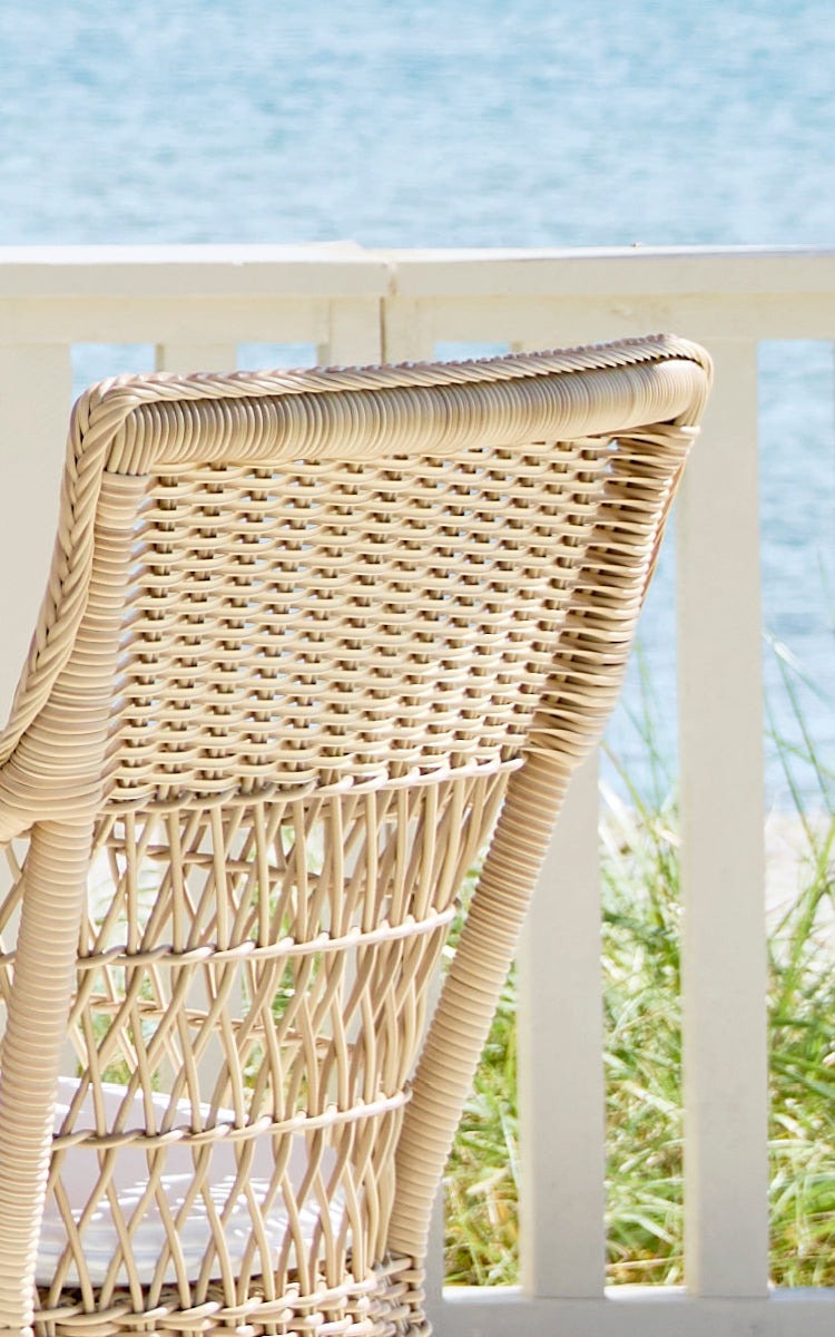 Dette er et nærbillede af Marie Exterior Armchair i natural artfibre aluminium. Detalje af den flettede gitterryg og armlænsomvikling.