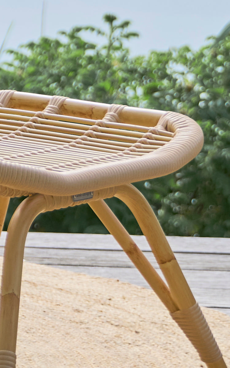 Dette er et nærbillede af Monet Exterior Footstool i natural aluminium artfibre. Detalje af det flettede sæde og de spredte ben.