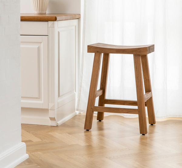 Dette er et livsstilsbillede af Charles Skammel i teak indoor, i et lyst hvidt interiør med lambrisering og sildebensgulv.
