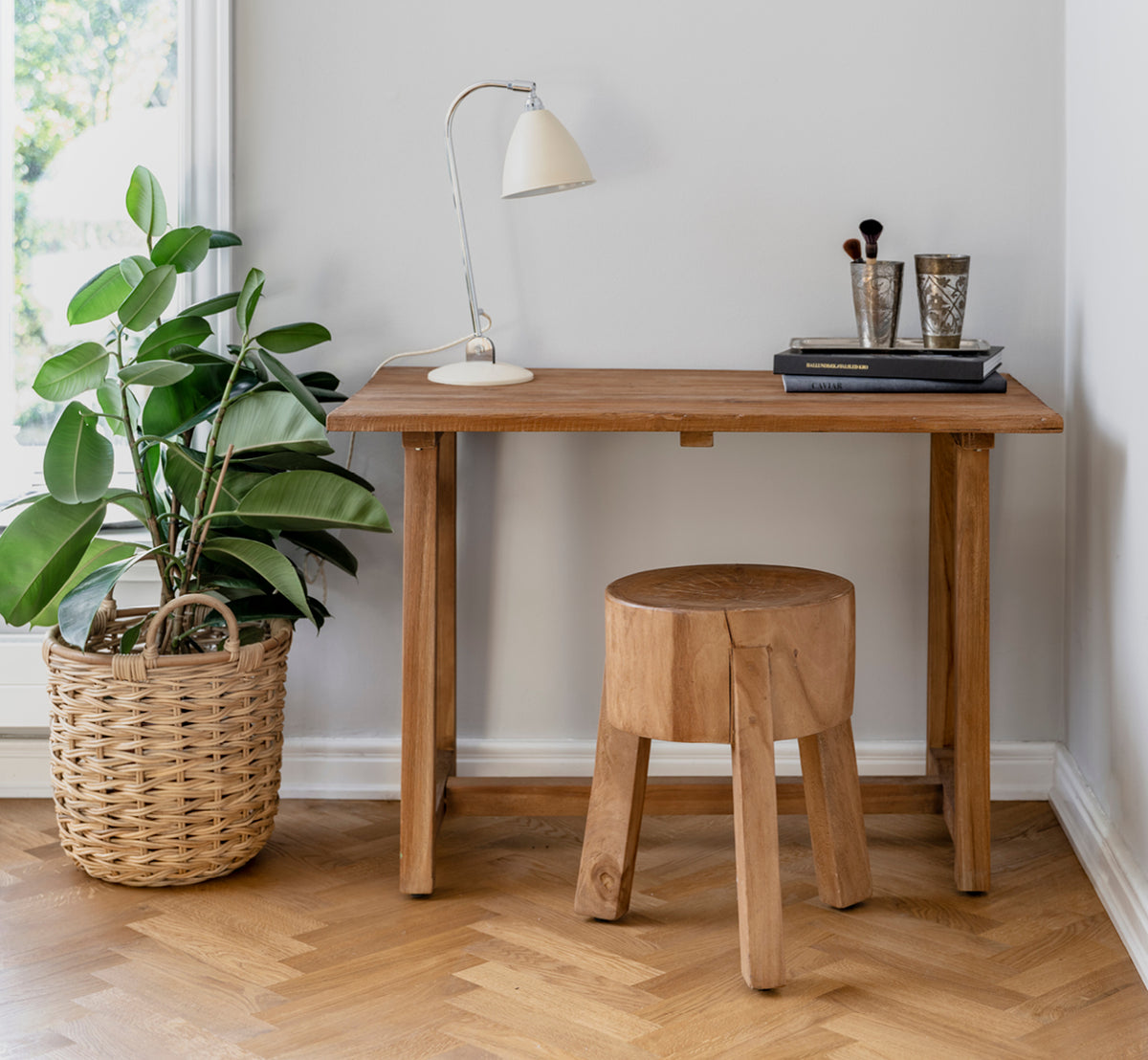 Dette er et livsstilsbillede af Roger Skammel i teak indoor. Placeret ved et træskrivebord med lampe og plante i en lys sildebensgulv-arbejdsstue.