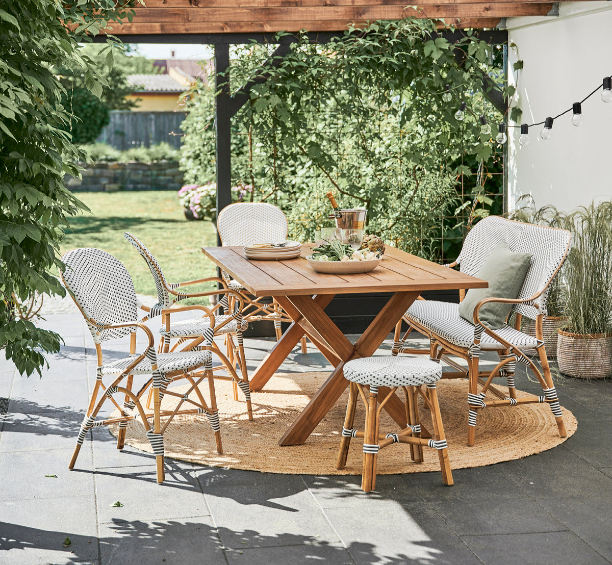 Dette er et livsstilsbillede af Isabell Spisestuelænestol i white w cappuccino dot ArtFibre Skin on Rattan frame, i et lyst spiseområde med store.