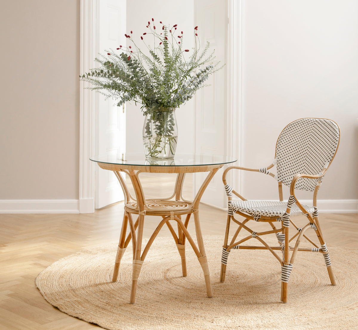 Dette er et livsstilsbillede af Isabell Spisestuelænestol i white w cappuccino dot ArtFibre Skin on Rattan frame, i et lyst spiseområde med store.