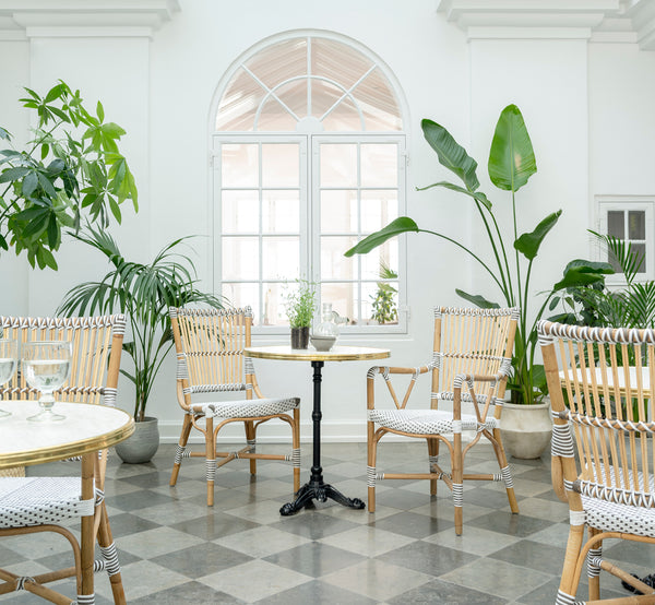 Dette er et livsstilsbillede af Monique Spisestuelænestol i white w cappuccino dot artfibre skin on rattan frame. Stylet i et lyst interiør.