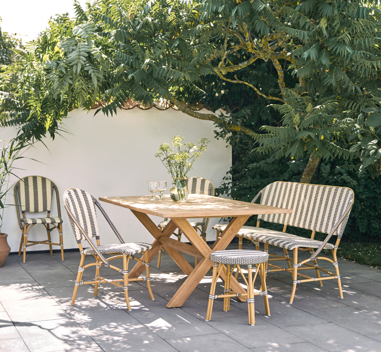 Dette er et livsstilsbillede af Colonial Bord 160 i outdoor Teak, på en strandterrasse med hvidt trædæk og havudsigt.