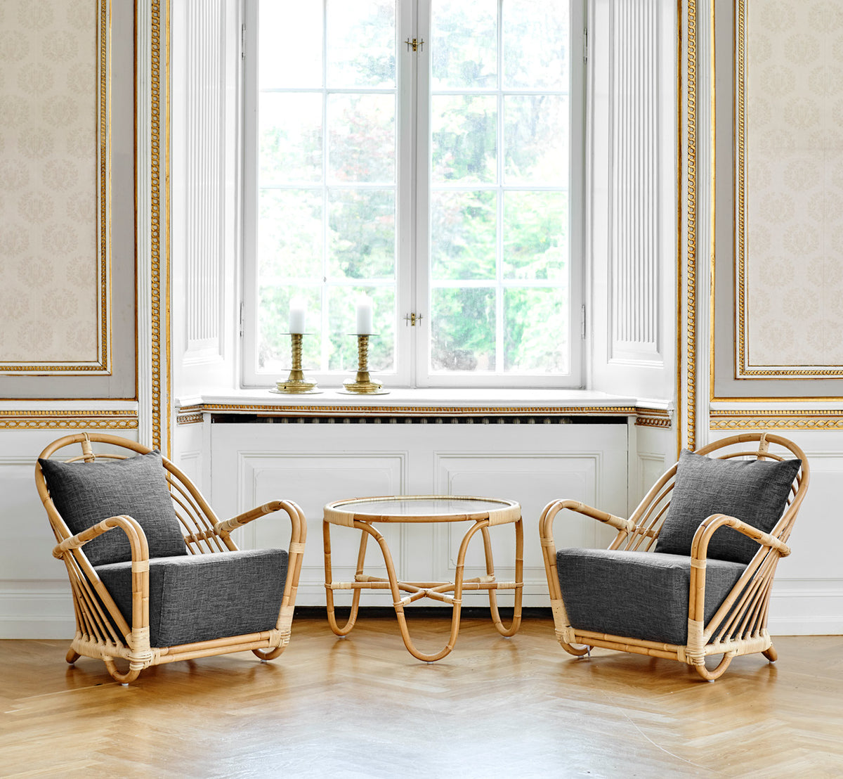 Dette er et livsstilsbillede af Charlottenborg Lænestol i polished Natural Rattan, i et elegant klassisk interiør med forseggjorte forgyldte.