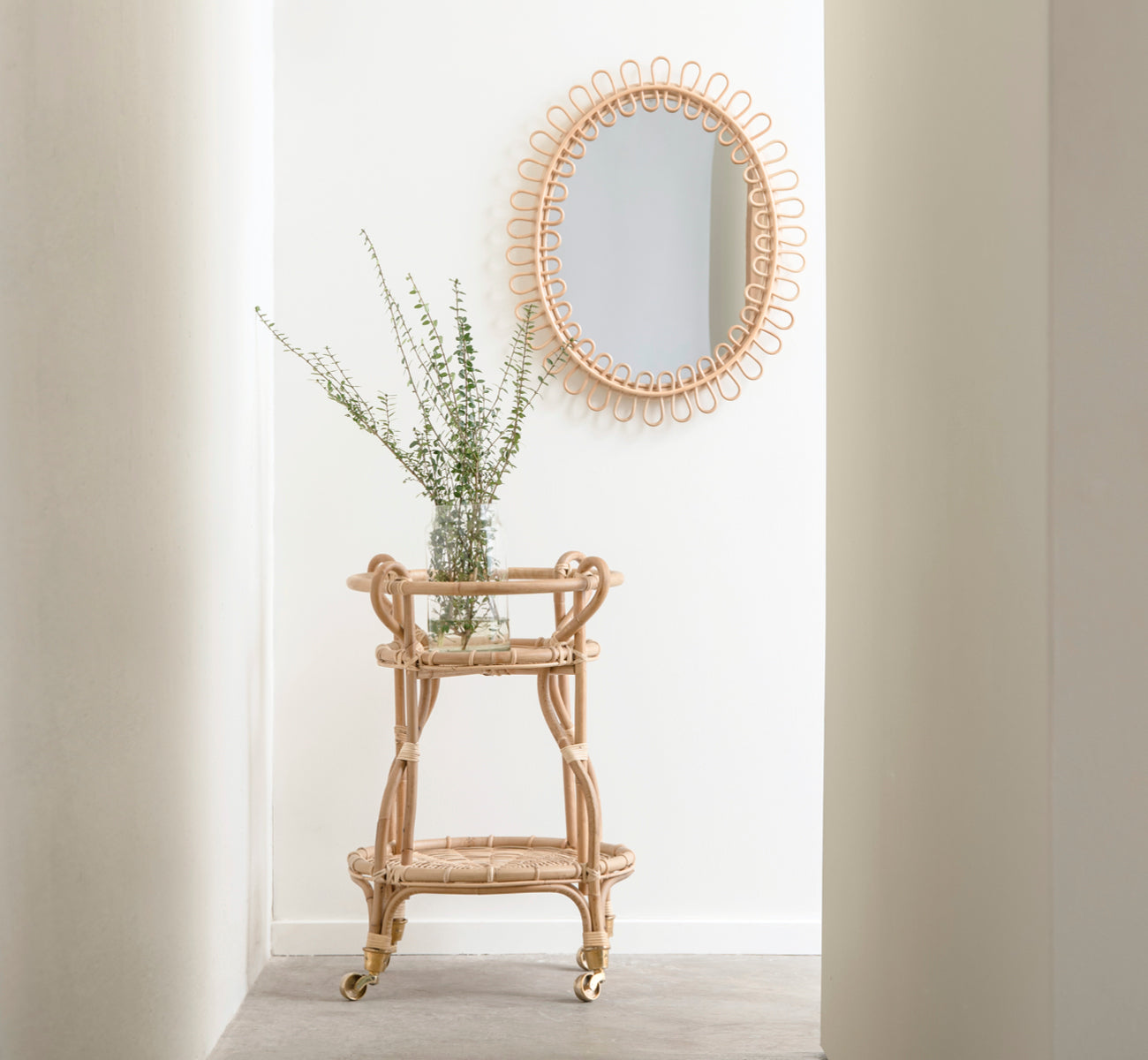 Dette er et livsstilsbillede af Fratellino Serveringsvogn i polished Natural Rattan, i et klassisk interiør med forseggjorte hvide paneldøre.