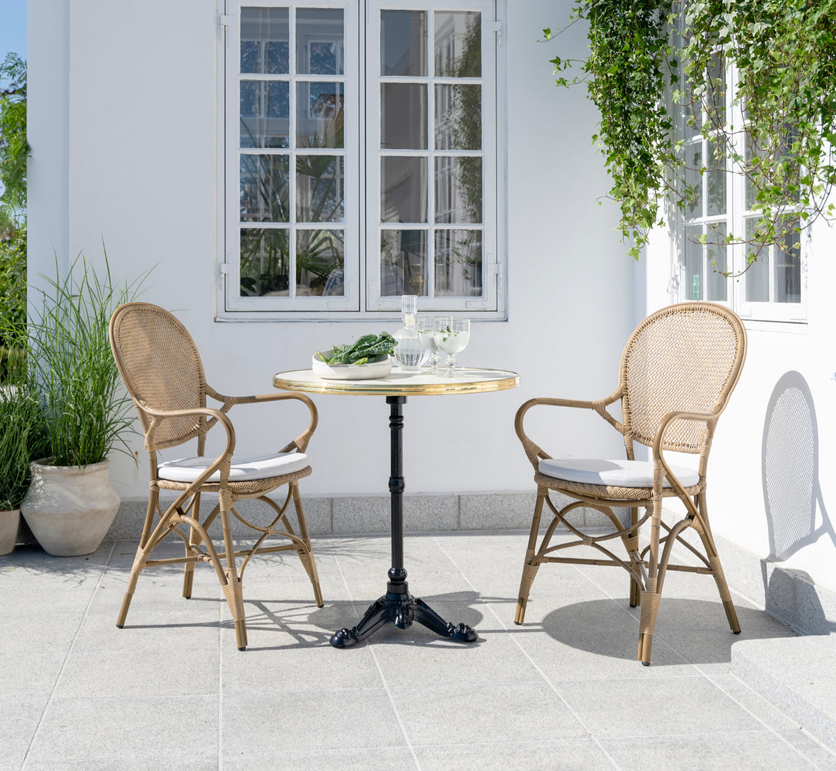 Dette er et livsstilsbillede af Rossini Udendørs spisestuelænestol i antique aluminium artfibre. Stylet i et lyst interiør.