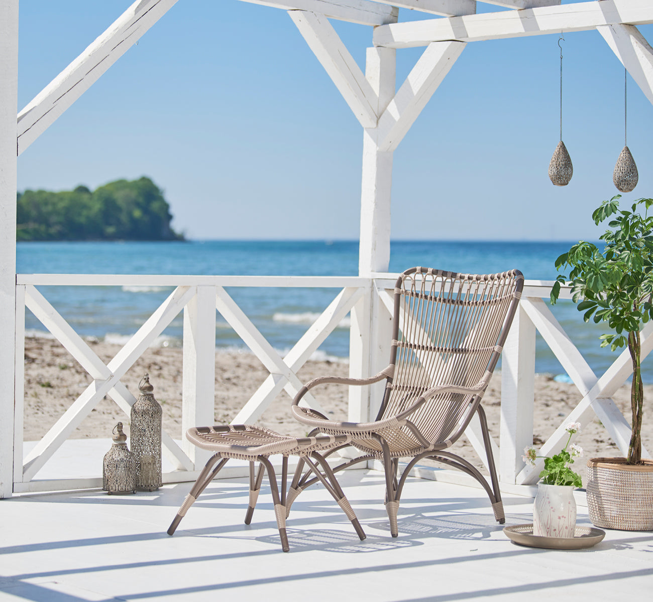 Dette er et livsstilsbillede af Monet Exterior Lounge Chair i moccaccino aluminium artfibre. Stylet i et lyst interiør.