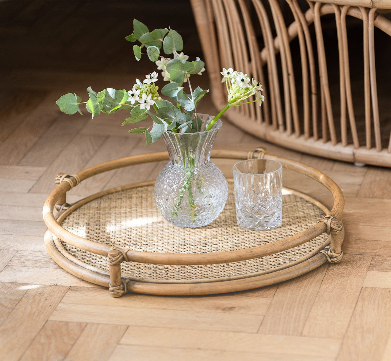 Dette er et livsstilsbillede af Andreas Bakke i natural Rattan, i et lyst interiør med sildebensgulv.