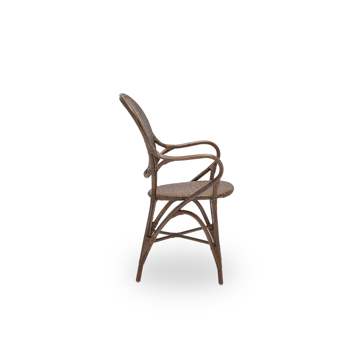 Ren sidevisning af Rossini spisebordsarmstol, i brun rattan. Designet i 1993 af Knud Andreasen fra Sika-Design sammen med den japanske designer Yamakawa og er husets signaturstol. Håndlavet i indonesisk rattan af høj kvalitet.