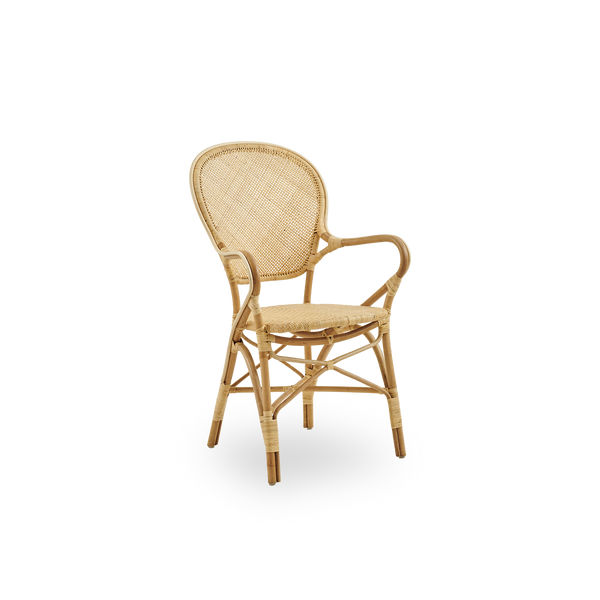 Side view af Rossini spisestol med armlæn i naturlig rattan. Elegant fletstol med rund ryg og armlæn i simpelt design. Håndlavet i højkvalitets rattan.
