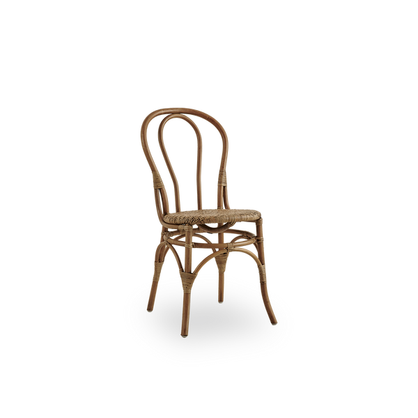 Side view af Lulu spisestol i Antique brown farve, håndlavet i højkvalitets indonesisk rattan. Letvægts, elegant design med rund, enkel ryg.