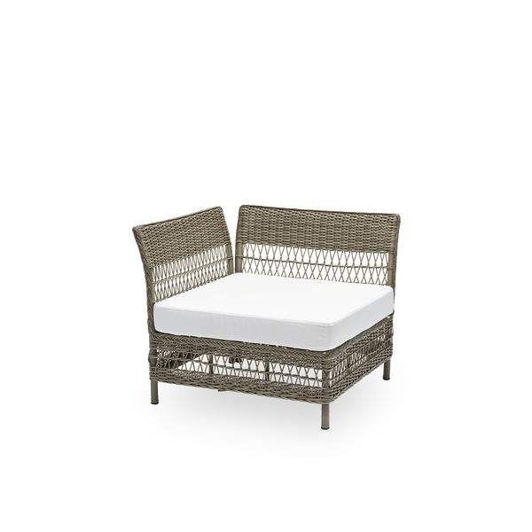 Sidevisning af Mona udendørs sofa, hjørnemodul med sædehynde, i antikgrå ArtFibre og aluminium. Del af Mona modulsofaen, der tilpasser sig formen på det uderum, den står i. Håndflettet i vejrbestandig ArtFibre på aluminiumsstel til udendørs brug.