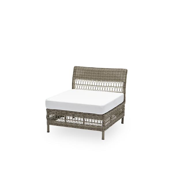 Sidevisning af Mona udendørs sofa, midtermodul med sædehynde, i antikgrå ArtFibre og aluminium. Del af Mona modulsofaen, der tilpasser sig formen på det uderum, den står i. Håndflettet i vejrbestandig ArtFibre på aluminiumsstel til udendørs brug.