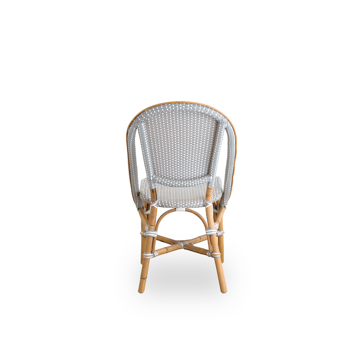 Bagfra vinkel af Sofie spisebordsstol i rattan, inspireret af fransk caféstil. Rattanramme med fuldt flettet sæde og ryglæn, håndlavet i ArtFibre i gråt med hvide prikker. Stabelbar rattan bistrostol.