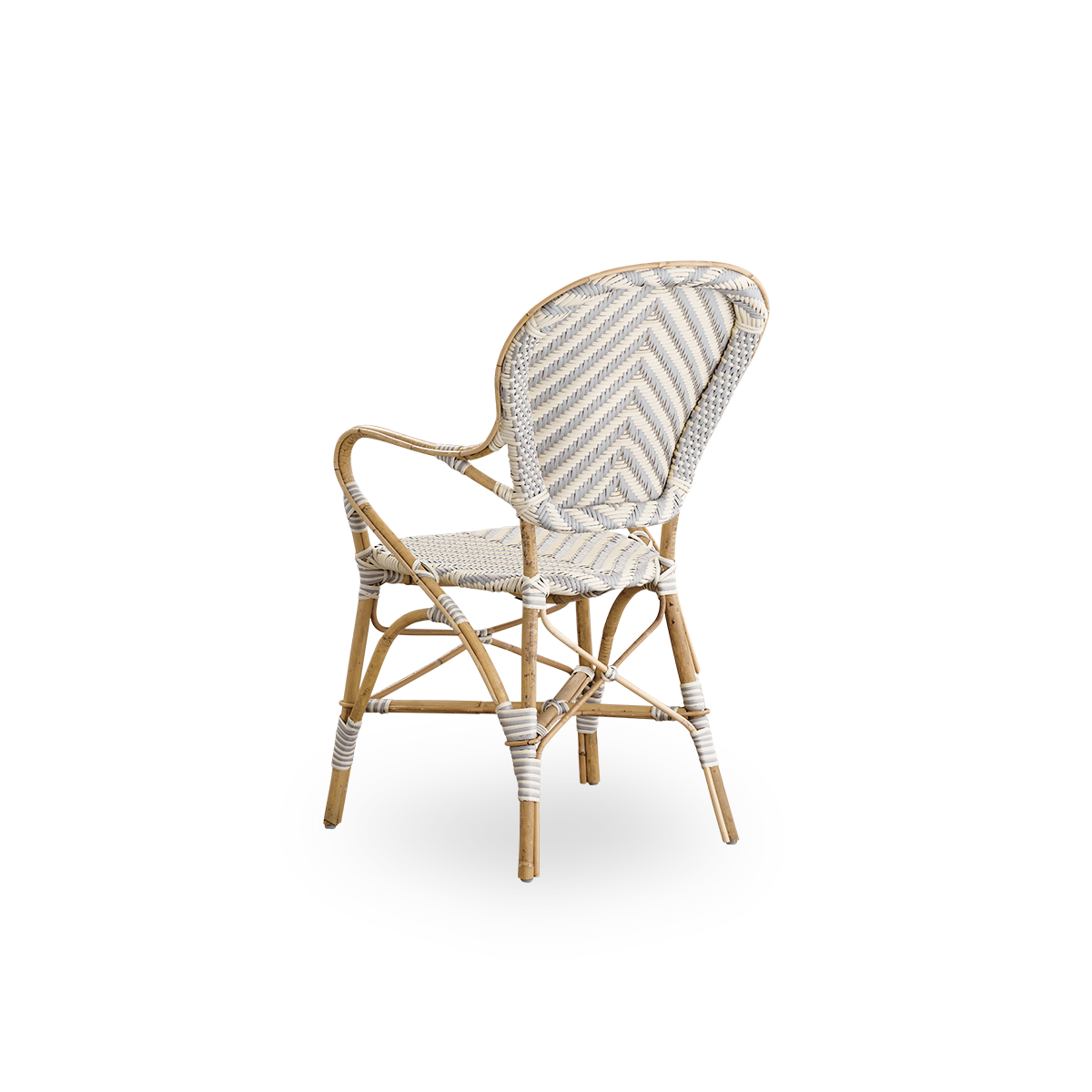 Sidevinkel bagfra af Isabell spisebordsstolen med armlæn.
Rattanramme med sæde og ryglæn i ArtFibre i et elfenbens- og gråt sildebensmønster. Inspireret af 1950’ernes bistrodesign.
