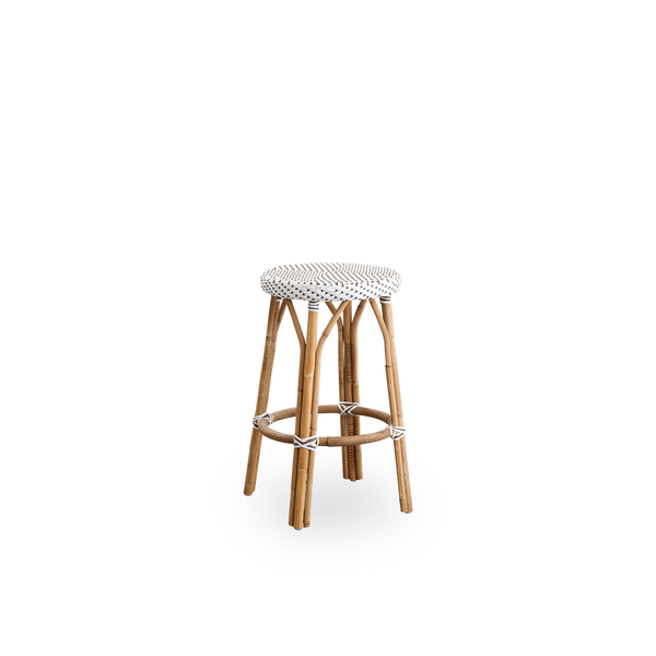 Side view af Simone bardiskstol, højde 68 cm. Rattan-ramme med fodstøtte og fuldt flettet rundt sæde håndlavet i ArtFibre i hvid med brune prikker. Stabelbar bardiskstol.