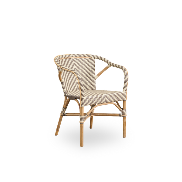 Side view af Madeleine spisestol med armlæn. Rattanramme med sæde og ryg flettet i ArtFibre med elfenbens- og brun fiskebensmønster. Inspireret af bistrodesign fra 1950’erne.