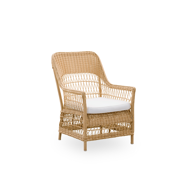 Side view af Dawn udendørs loungestol i Natural, inspireret af britisk kolonistil. Romantisk loungestol med armlæn og høj ryg. Fuldt flettet i ArtFibre på håndbøjet aluminiumsramme.