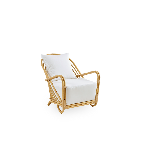 Side view af Charlottenborg udendørs loungestol i rattan-look, designet af Arne Jacobsen. Stolen har en buet ryg og armlæn integreret i basen, håndlavet med Alu-Rattan-ramme og flettede ArtFibre-detaljer.
