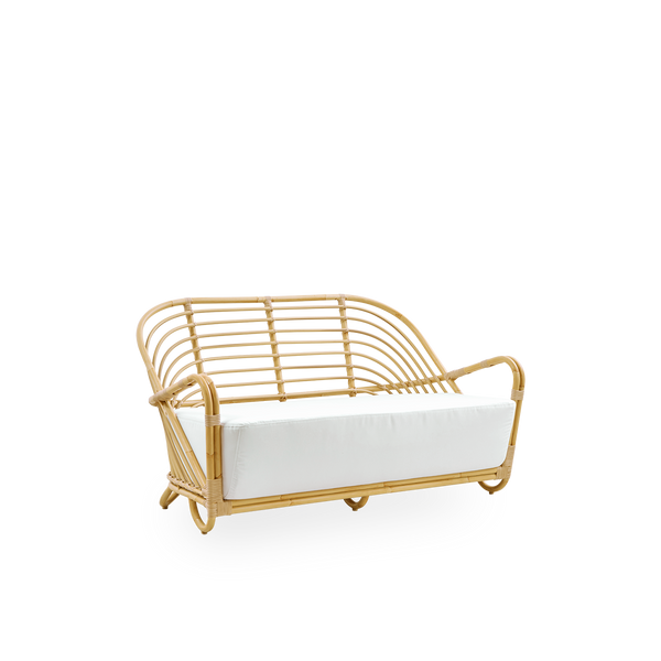 Side view af Charlottenborg udendørs 2-personers sofa i rattan-look, designet af Arne Jacobsen. Sofaen har en buet ryg og armlæn integreret i basen, håndlavet med Alu-Rattan-ramme og flettede ArtFibre-detaljer.
