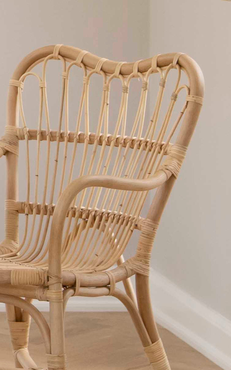 Dette er et nærbillede af Margret Spisebordsstol i natural rattan. Det håndvævede åbne ryglæn og det buede stel fremhæver håndværket.