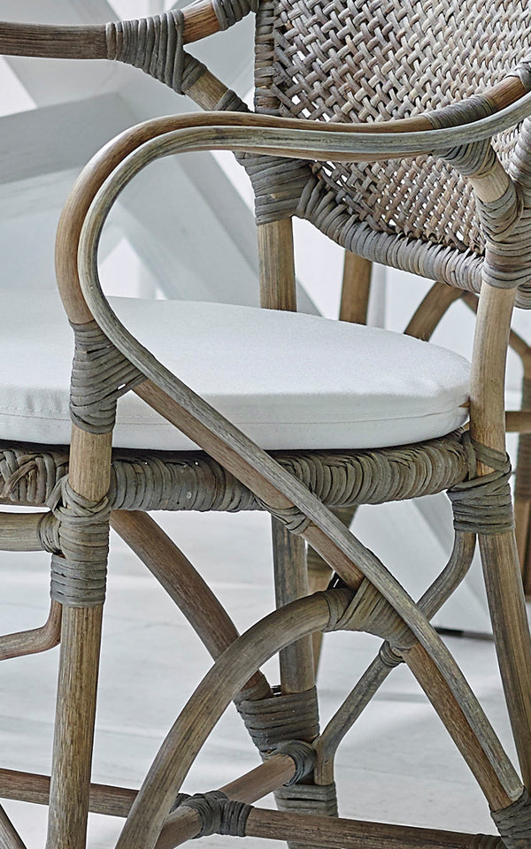 Dette er et nærbillede af Rossini Lænestol i taupe rattan. Detalje af forvitret taupe rattan med hvid sædehynde.