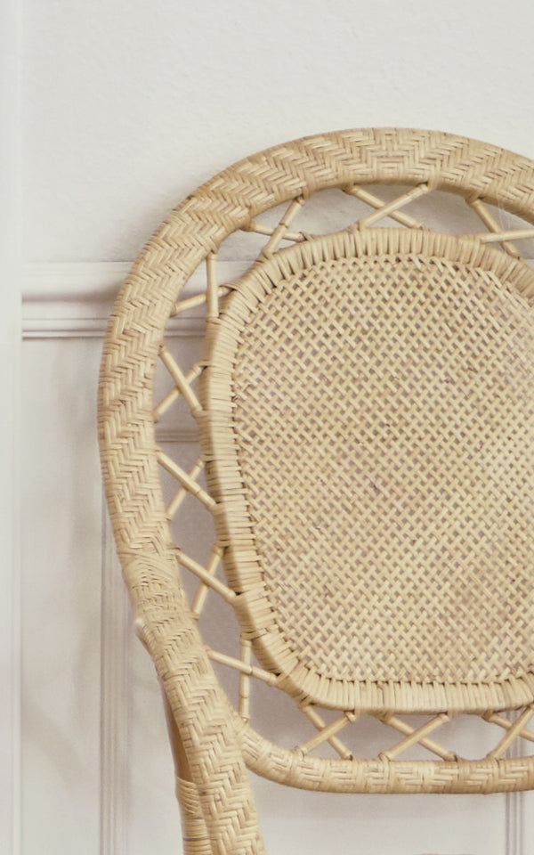 Dette er et nærbillede af Romantica Spisebordsstol i natural rattan. Det runde ryglæn har en sildebensvævet kant og et centrum af rørflet.
