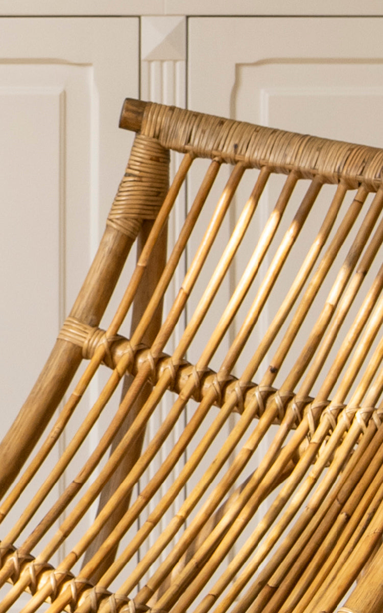 Dette er et nærbillede af Michelangelo Daybed i antique rattan. Detalje af den buede skulpturelle rattanstang-konstruktion og omviklede samlinger.