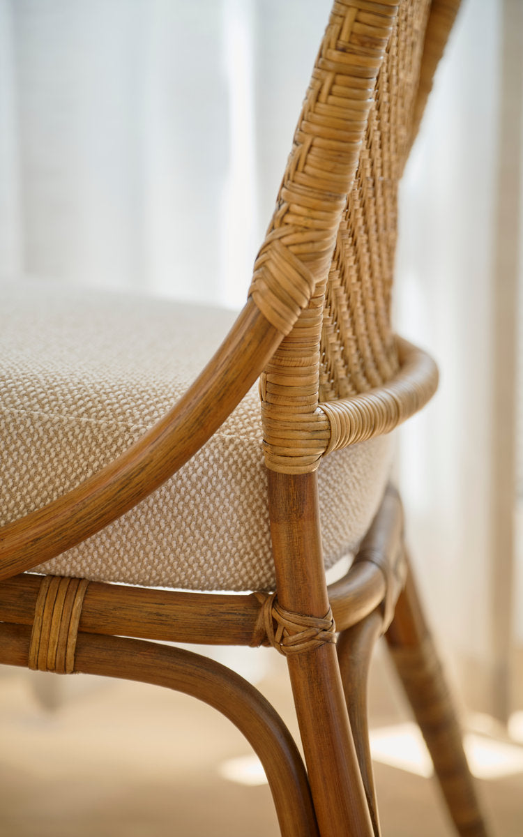 Dette er et nærbillede af Melody Spisebordsstol i antique rattan. Ryglæn i flet, polstret sæde og omviklede samlinger.