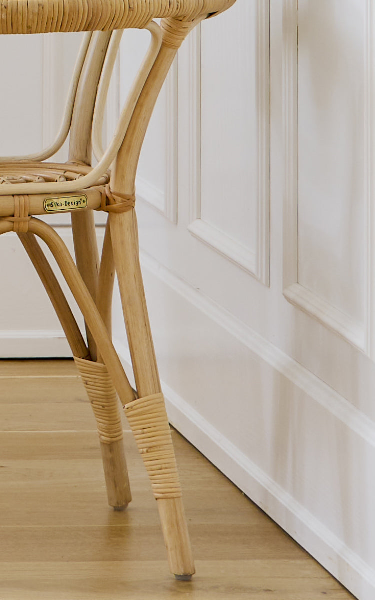 Dette er et nærbillede af Tony Side Table i natural rattan. Detalje af glaspladekanten og den omviklede rattanramme-konstruktion.