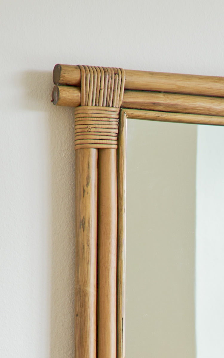 Dette er et nærbillede af Rasmus Mirror 172 cm i antique rattan. Detalje af de bundtede rattanstænger og omviklede hjørne af spejlrammen.