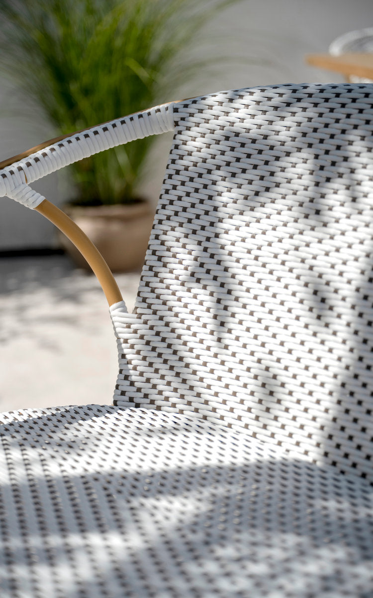 Dette er et nærbillede af Madeleine Udendørs bænk i almond aluminium frame white w cappuccino dot artfibre. Flettet ryglæn i spredt lys.