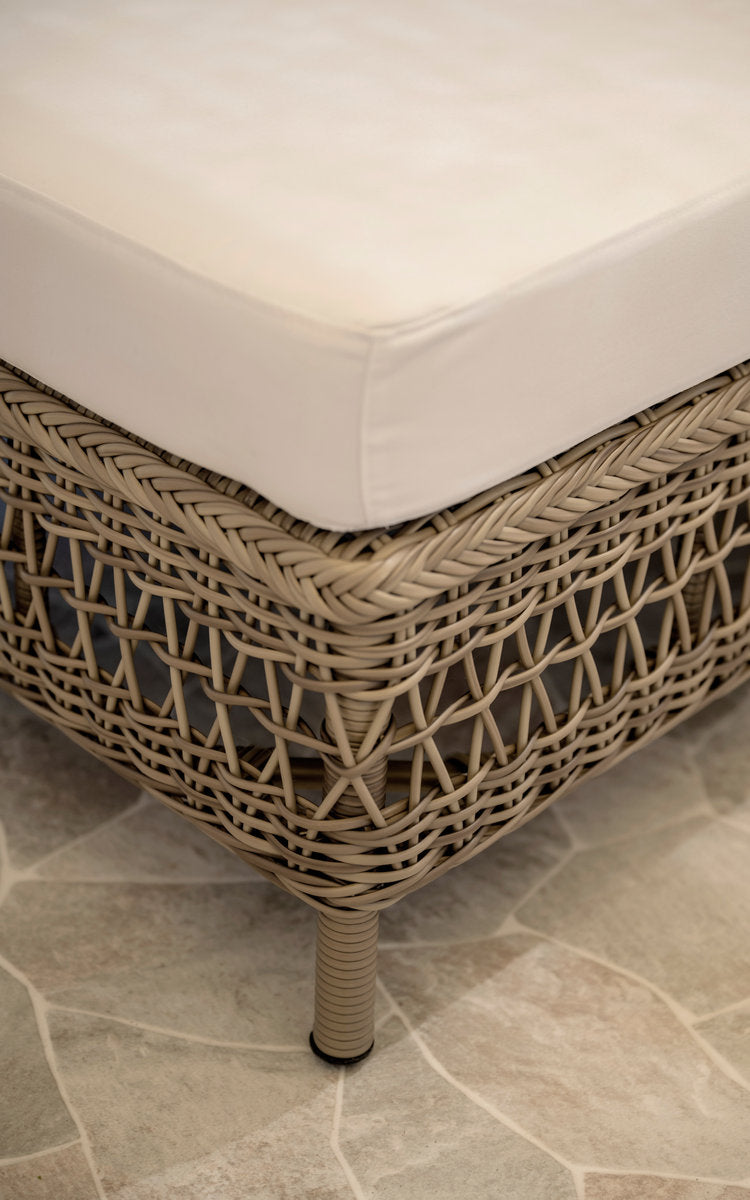 Dette er et nærbillede af Mona Udendørs modulsofa-Pouf Module i antique grey artfibre aluminium. Flettet pufkant med hvid pude.
