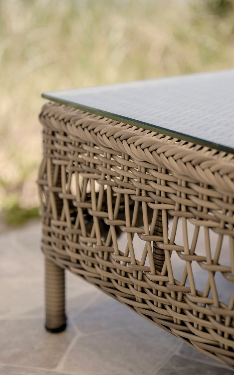 Dette er et nærbillede af Mona Udendørs modulsofa-Pouf Module w. Glass i antique grey artfibre aluminium. Åben flet under en glasplade.