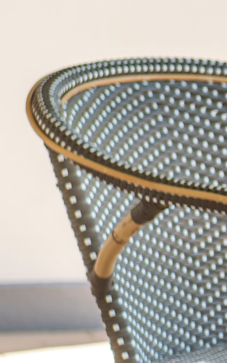 Dette er et nærbillede af Madeleine Spisebordsstol i cappuccino w white dot rattan frame. Tekstureret prikkeflet med varme toner.