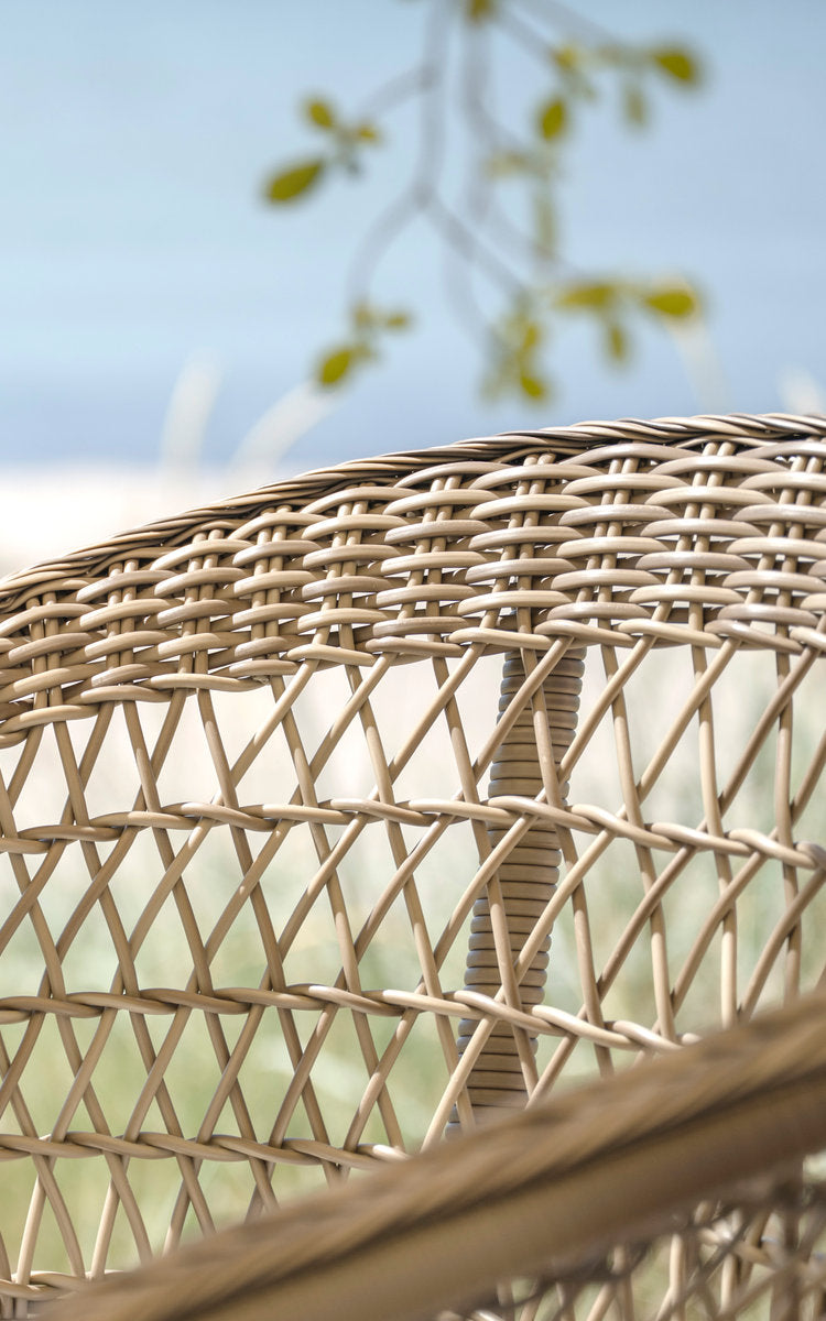 Dette er et nærbillede af Emma Udendørs barstol i antique grey artfibre aluminium. Ryglæn i åben rudeflet ved havet.