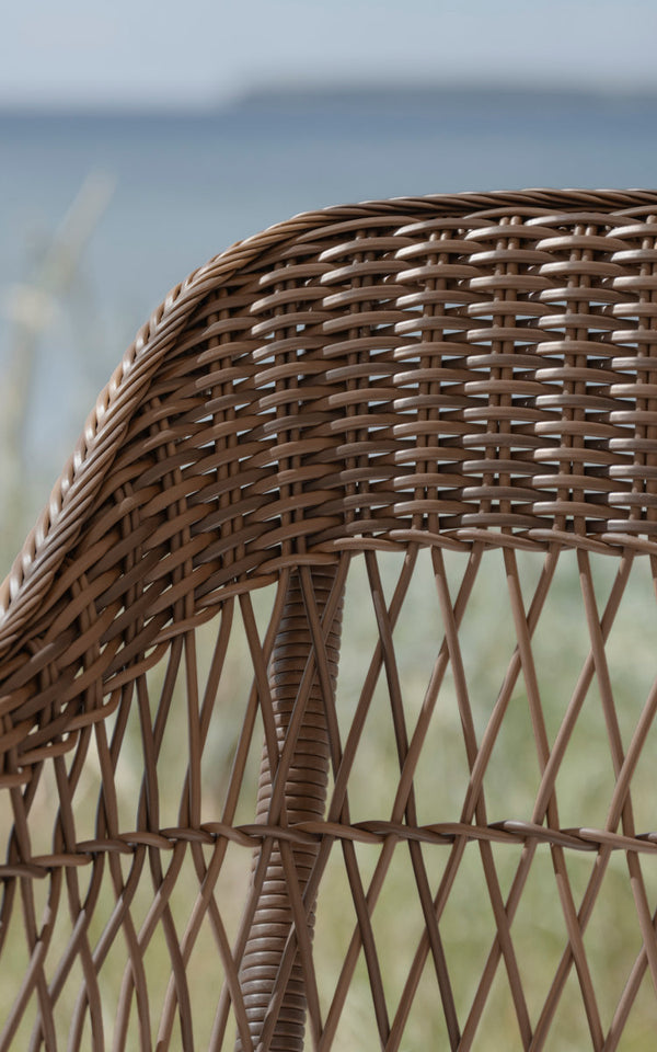 Dette er et nærbillede af Charlot 3-personers udendørs sofa i brown artfibre aluminum. Ryglæn i åben flet med havudsigt.