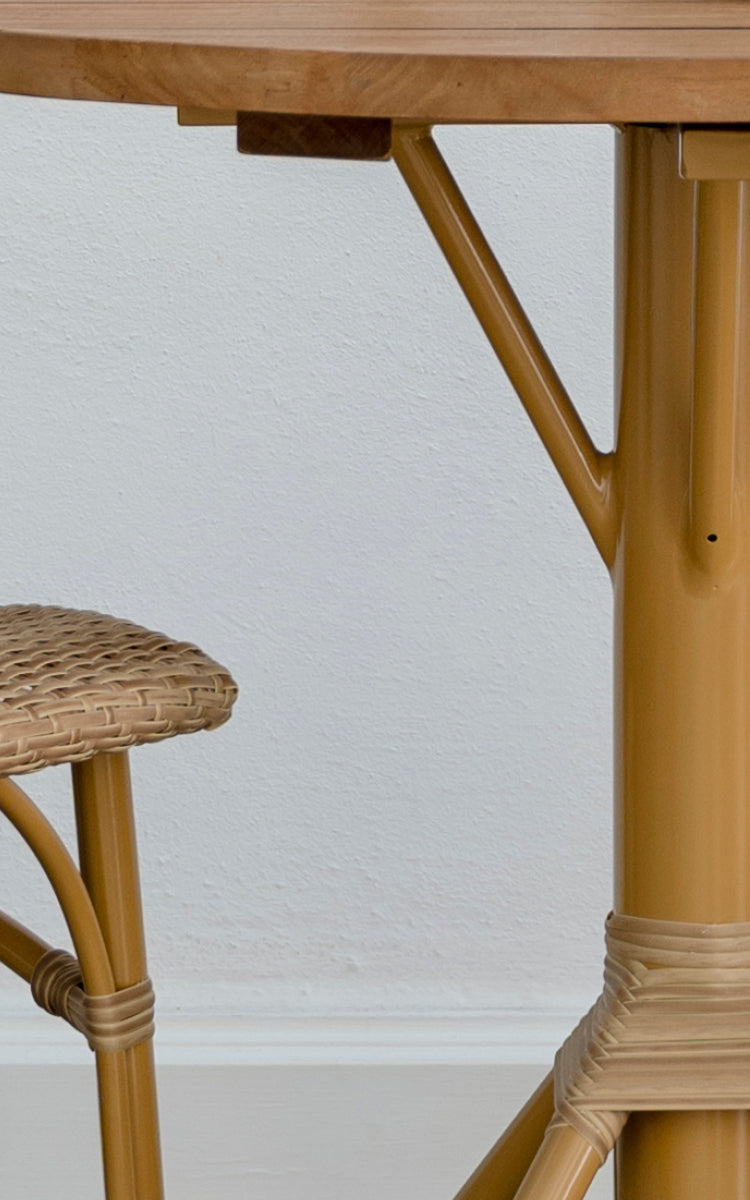 Dette er et nærbillede af Nicole Cafe Table i almond aluminium frame natural ArtFibre. Detalje af teaktoppen og fodomviklingen.