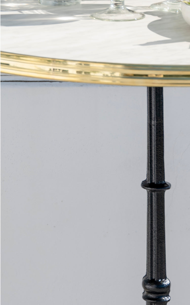 Dette er et nærbillede af Lyon Barbord Versalite Marble Ø70 cm i cast iron. Marmortop og detaljeret støbejernssøjle med drejet profil.
