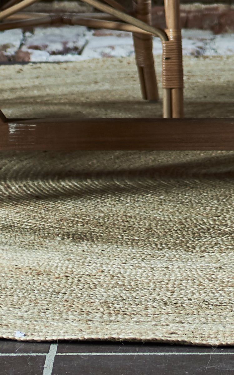 Dette er et nærbillede af Jute Carpet Ø280 i natural jute. Det tætvævede koncentriske mønster og den naturlige kant viser det runde tæppe.