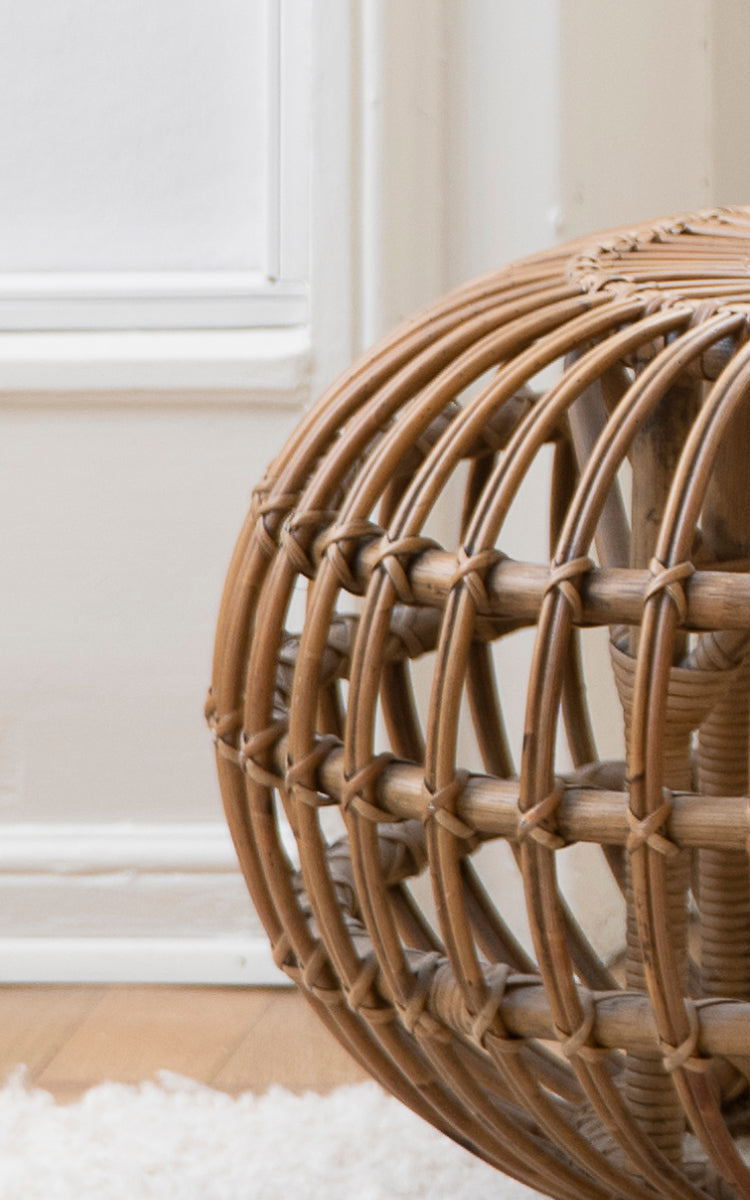 Dette er et nærbillede af Ottoman Small i polished antique rattan. Detalje af den åbne rattanburkonstruktion med krydsbundne bindinger.