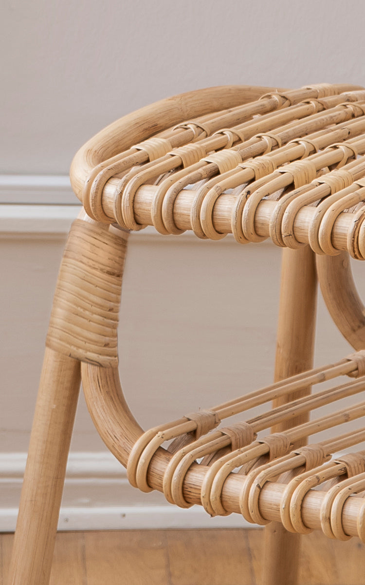 Dette er et nærbillede af Machiya Skammel i natural skin on rattan. Sløjfeflettet rattansæde og omviklet rammefuge i varme toner.