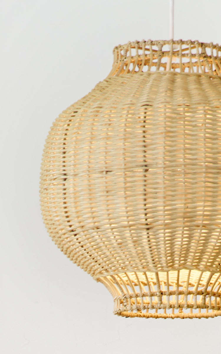 Dette er et nærbillede af Tomos Lampeskærm i natural core weave rattan frame. Den afrundede løgform med det intrikate fletværk er vist.