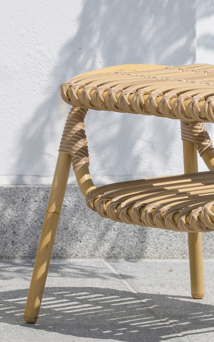 Dette er et nærbillede af Machiya Udendørs skammel i natural aluminium artfibre. Flettet ArtFibre-sæde og omviklede samlinger på udendørs terrasse.